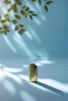 Elegant golden lighter resting on a softly lit blue surface surrounded by natural shadows and leaves photo
