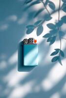 Metal lighter rests against a blue wall, casting unique shadows from nearby leaves during the soft light of late afternoon photo