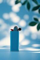 Bright blue lighter stands out against a soft blue background with natural light and shadows photo