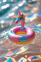 Colorful unicorn float sits in sparkling water on a sunny day by the pool photo
