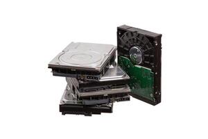 A collection of outdated and potentially non-working hard drives, isolated on a white background, revealing their internal parts and connectors. photo