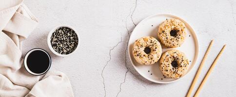 Rice donuts with meat and sesame seeds on a plate on the table top view web banner photo