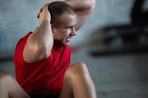 A muscular man performing crunches in the gym, focusing on building core strength and achieving his fitness goals photo
