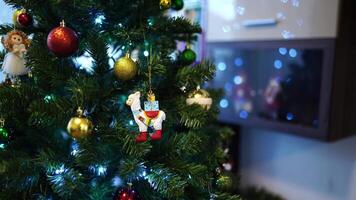Figurine of a sheep with gifts on its back hangs on a Christmas tree next to bright balls video
