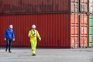 Workers inspecting shipping containers at port, Engineer man walking in industry containers cargo, Foreman dock workers in hardhat at shipping container yard photo