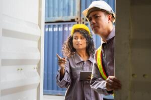 Logistics team discussion at shipping yard, Container yard workers and supervisor reviewing documents, Foreman dock worker in hard hat checking contrainer box at cargo containers photo