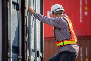 Logistics professional inspecting containers, Engineer man checking containers box in in Industry containers yard photo