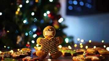 Cookie man in a protective mask stands against the backdrop of a Christmas tree video