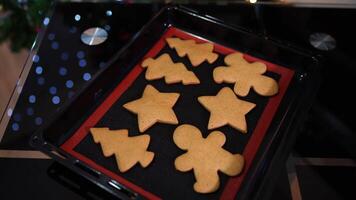 Figured gingerbread cookies lie on a baking sheet on the table video