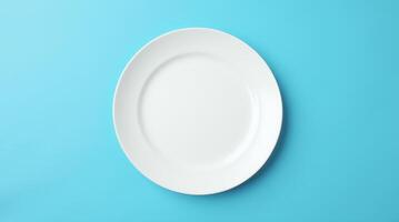 Empty white round plate on blue background. Minimalist tableware, dining, food presentation, restaurant, and kitchen concept photo