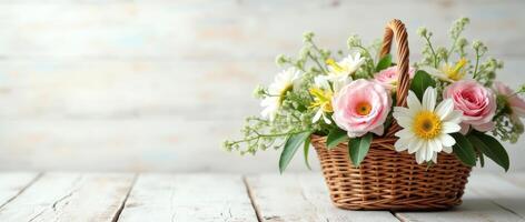 Wicker basket with pink roses, white daisies, and green leaves on rustic wooden table. Floral arrangement for greeting card or wedding decor with copy space photo