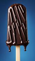 Close-up of chocolate ice cream bar with melting glossy chocolate drizzle on blue background. Sweet dessert and summer treat concept photo