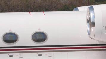 Shots of windows and engine on white plane with unrecognizable livery video