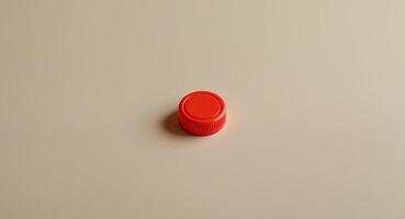 Close up of a Small Red Plastic Calculator Button on a Beige Background photo