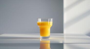 Glass of orange juice on a table with reflection. photo