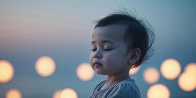 Child with closed eyes surrounded by soft glowing lights creates a serene and dreamy atmosphere during a peaceful evening. photo