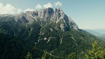 A mountain range with trees and a blue sky in the background video