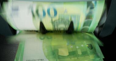 A pile of money is being counted by a machine video
