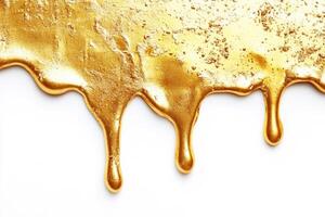 Bright gold paint dripping on a white surface creates texture photo