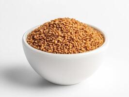 Brown sesame seeds in white bowl on plain background photo
