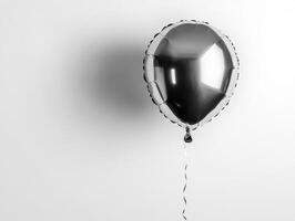 Silver balloon floating against a plain white wall background photo