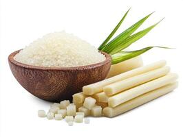 Fresh sugarcane and raw sugar on display with green leaves photo