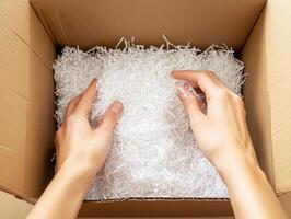 Arranging packing material in a cardboard box for shipping photo