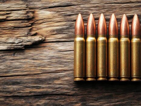 Close-up view of ammunition resting on a wooden surface photo