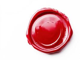 Red wax seal resting on a white surface in natural light photo