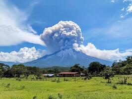 Volcano erupts with ash cloud over green landscape during daytime photo
