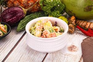 A bowl of salad with a coconut and a bunch of other vegetables photo
