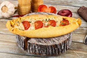 A bread roll with tomatoes and garlic on it photo