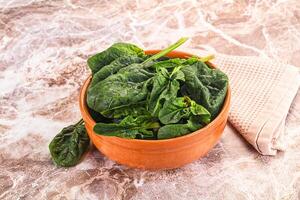 A bowl of spinach on a marble counter photo