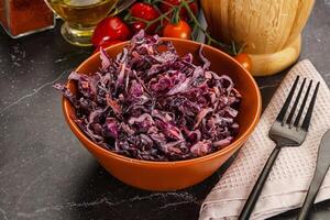 A bowl of red cabbage with a fork and knife photo
