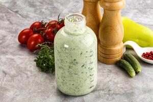A bottle of dressing with vegetables and spices photo