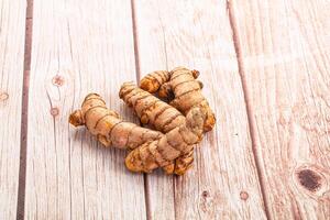 A pile of ginger root on a wooden table photo