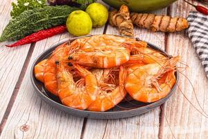 A bowl of shrimp on a wooden table photo