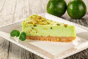 A slice of lime cheesecake on a white plate photo