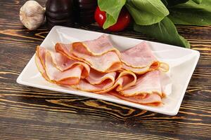 A white plate with sliced ham and vegetables photo