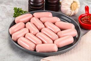 A plate of sausages on a table with garlic and other ingredients photo