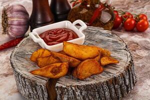 A plate of fries and ketchup on a wooden table photo
