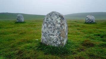 Standing stones in a green field on a misty day photo