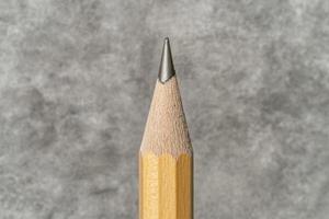 Close up of a sharpened pencil against a textured background photo