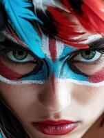 Close up of a womans face with colorful face paint and feathers photo