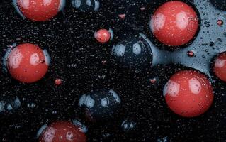 Abstract red and black spheres with water droplets on a dark background photo