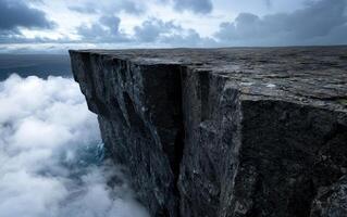Dramatic cliff edge with clouds, ocean, and sky photo