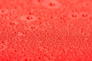Red plastic with water drops macro photo. Abstract red background with drops. photo