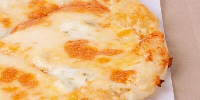 Pizza with sauce and cheese in a cardboard box macro photo isolate on white.