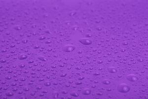 Violet plastic with water drops macro photo. photo