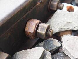 A detailed view showing rusty railroad tracks with a mossy texture, showing the texture fading with age, symbolizing neglect and the unique beauty in the transition of materials. photo